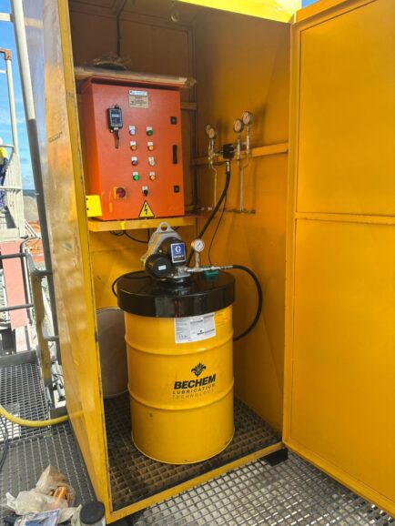 Industrial automatic lubrication system with grease pump, control panel and pressure gauges installed on mining equipment